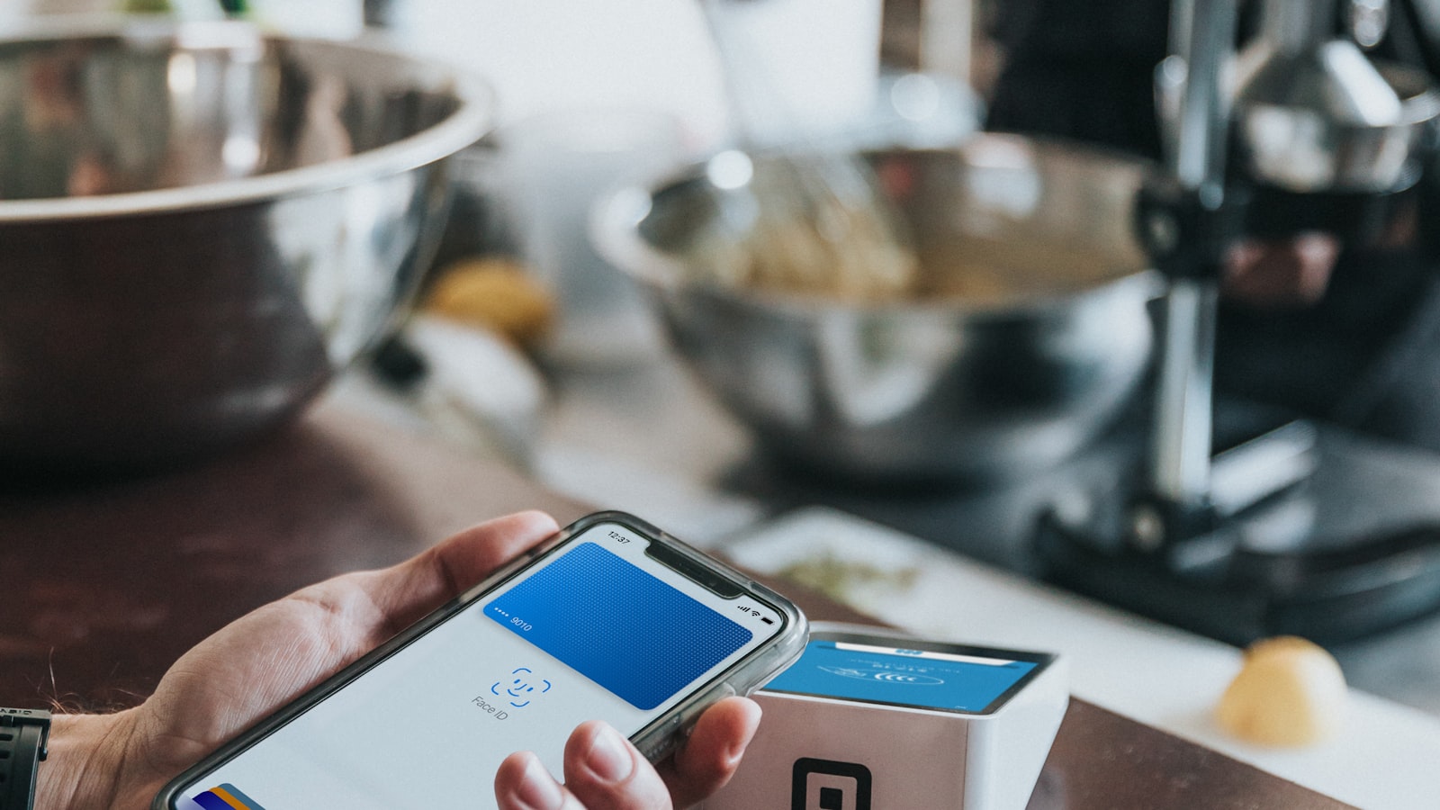 A staff member operating a point-of-sale terminal in a busy restaurant